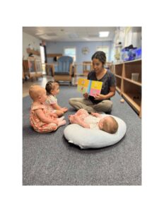 Young children sitting on the carpet during a Montessori reading activity with a teacher, learning sight words through engaging storytelling.