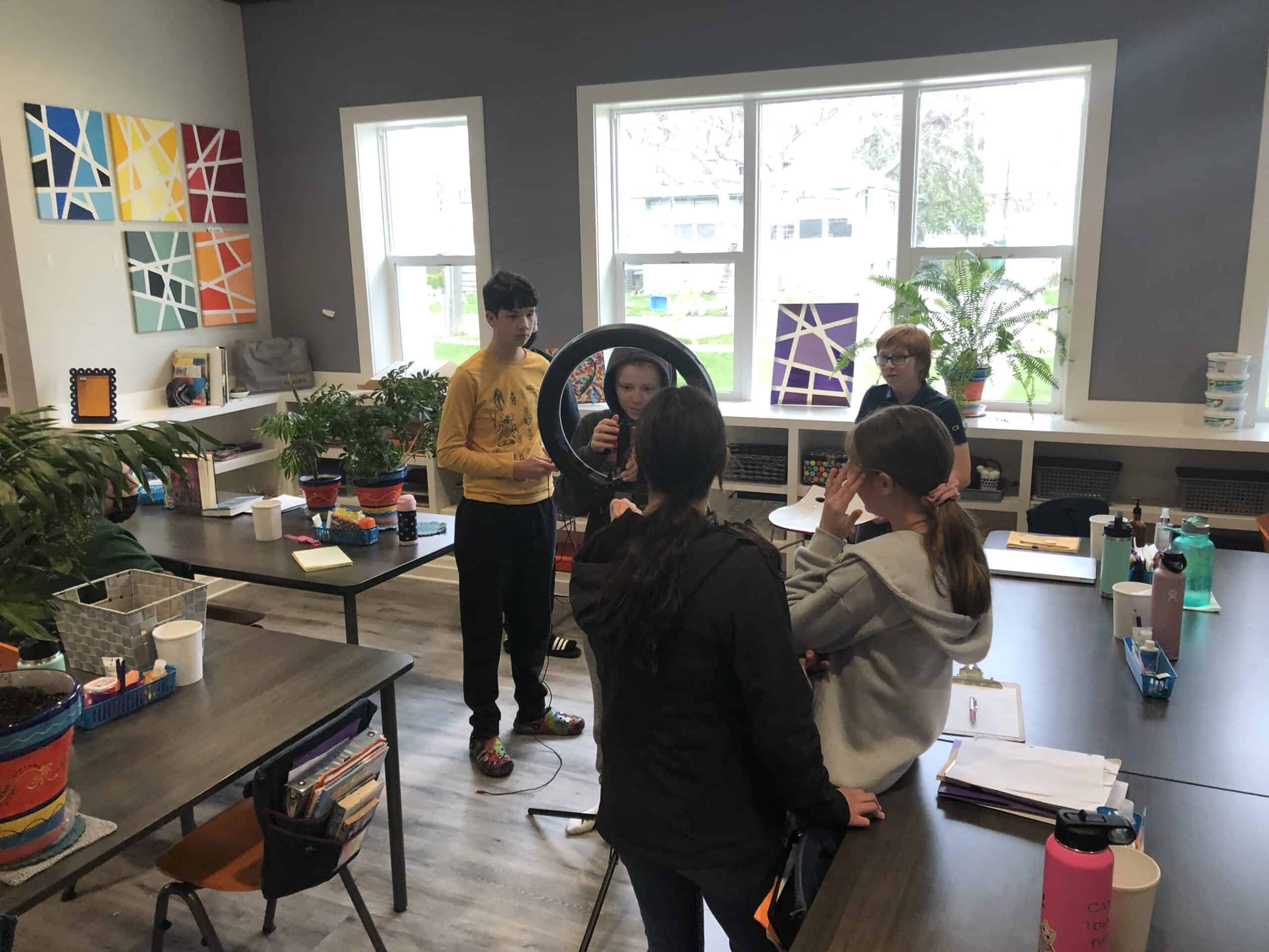 Creative Projects in Montessori Middle School | Media & Film A group of middle school students collaborating on a movie-making project using a ring light and camera, showcasing the creative and technology-integrated Montessori curriculum.