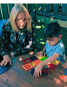 Montessori teacher observing a child building with magnetic tiles at Montessori Stepping Stones in Mount Clemens, MI