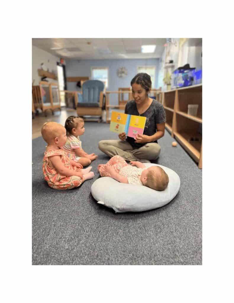 Montessori Teacher Reading to Infants Montessori teacher reading a picture book to infants at Montessori Stepping Stones in Mount Clemens, MI